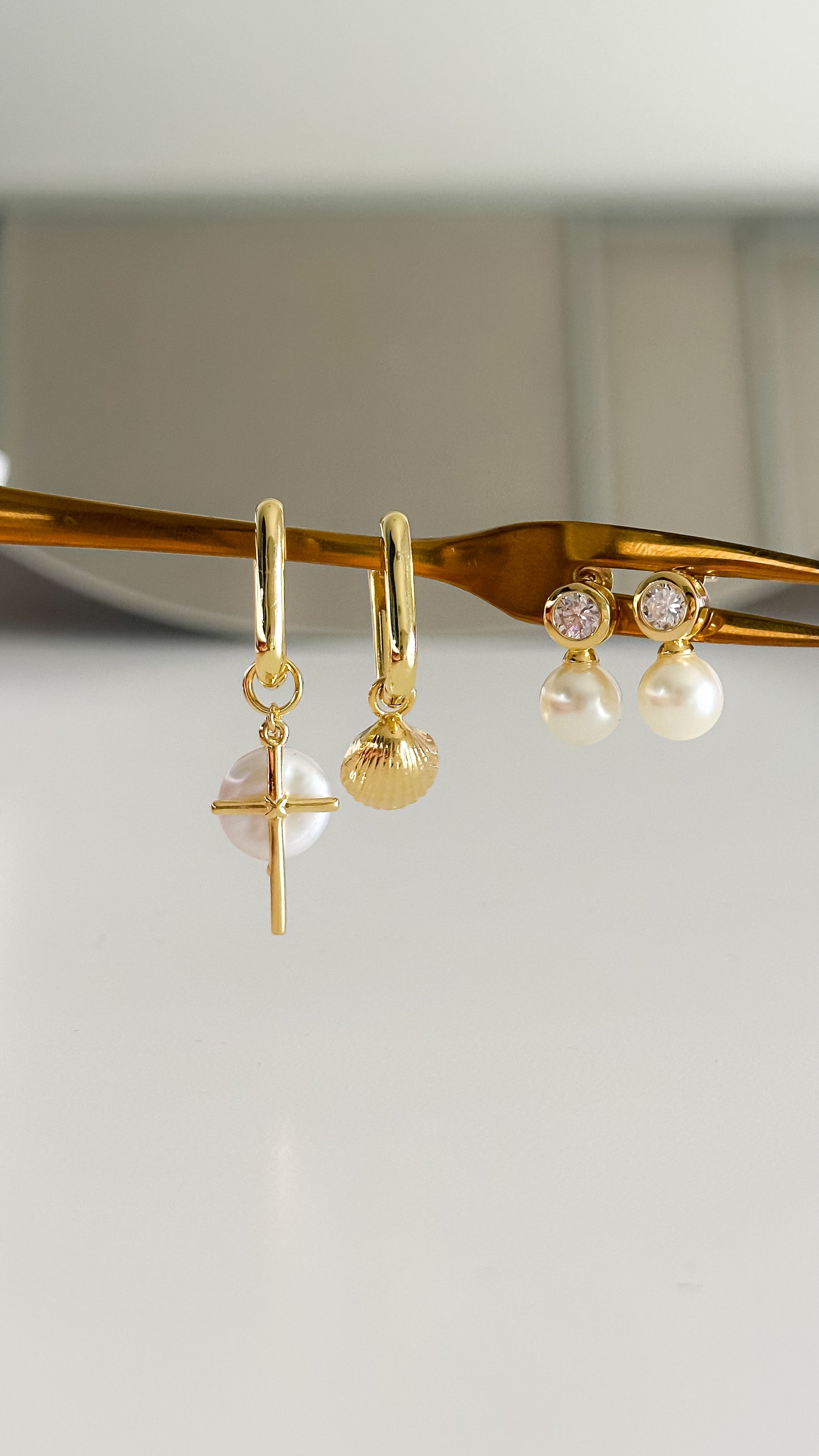 Detalle aros desiguales perla cruz y conchita de mar enchapados en oro 18K - D'march Designs Chile