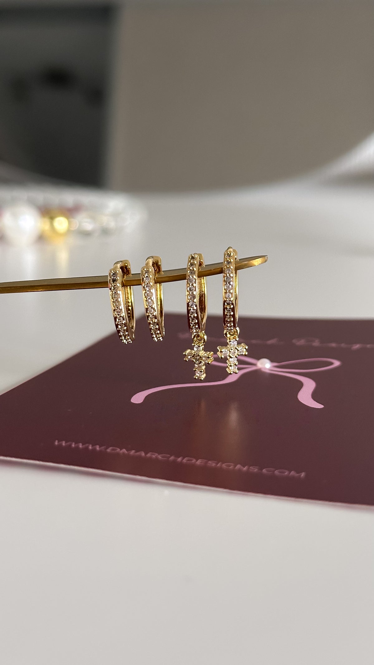 Detalle argollas huggies circones con cruz y argollas huggies con circones enchapadas en oro 18K - D'march Designs Chile