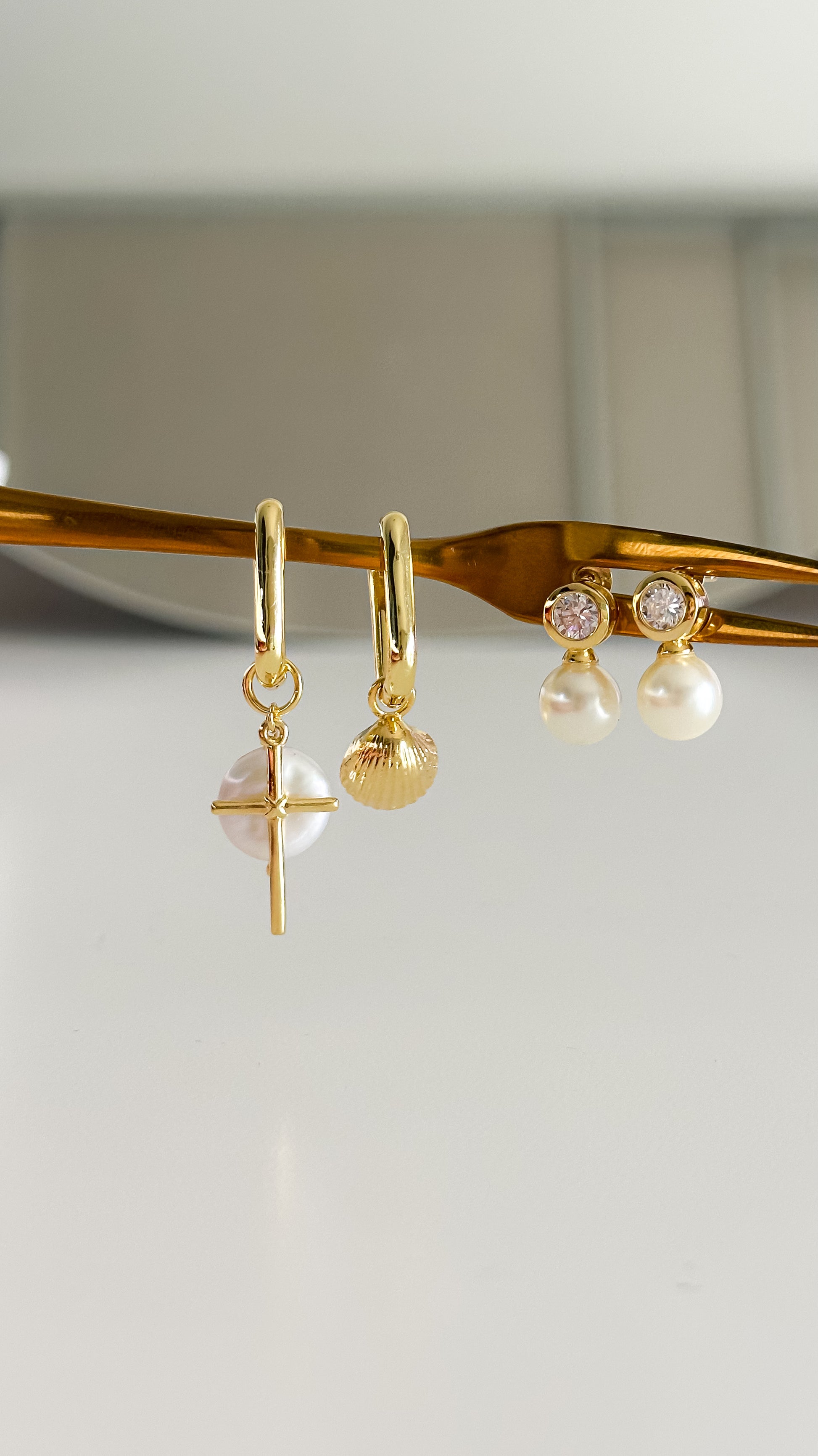 Detalle aros desiguales perla cruz y conchita de mar enchapados en oro 18K - D'march Designs Chile