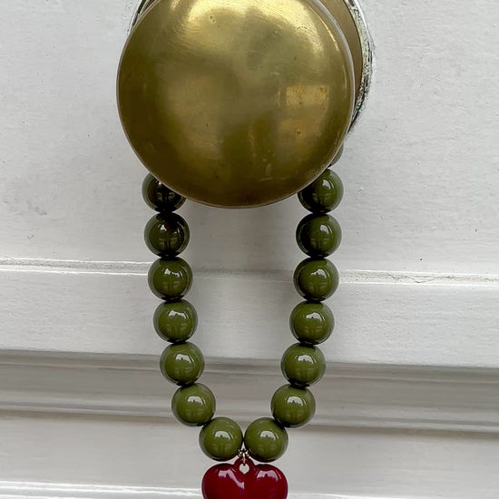 Video collar verde oliva 18mm con dije corazón burdeo y terminaciones enchapadas en oro 18K - D'march Designs Chile